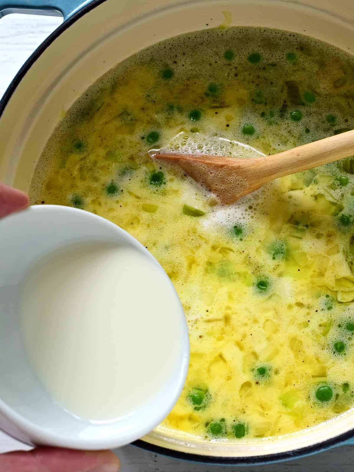 Putting cream into pea soup.