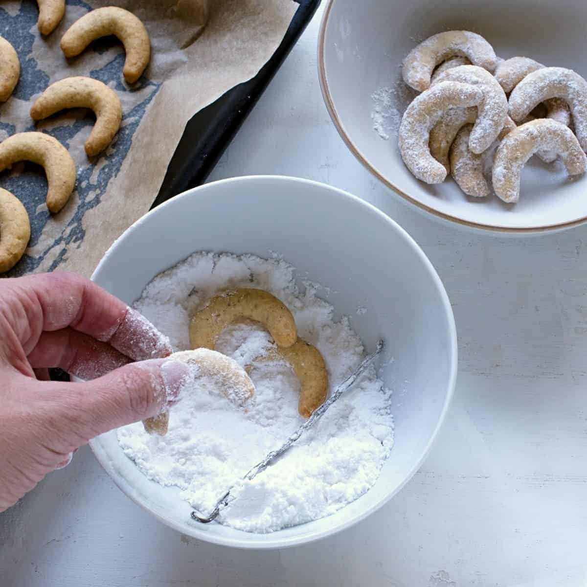 Coating vanilla crescent cookies.